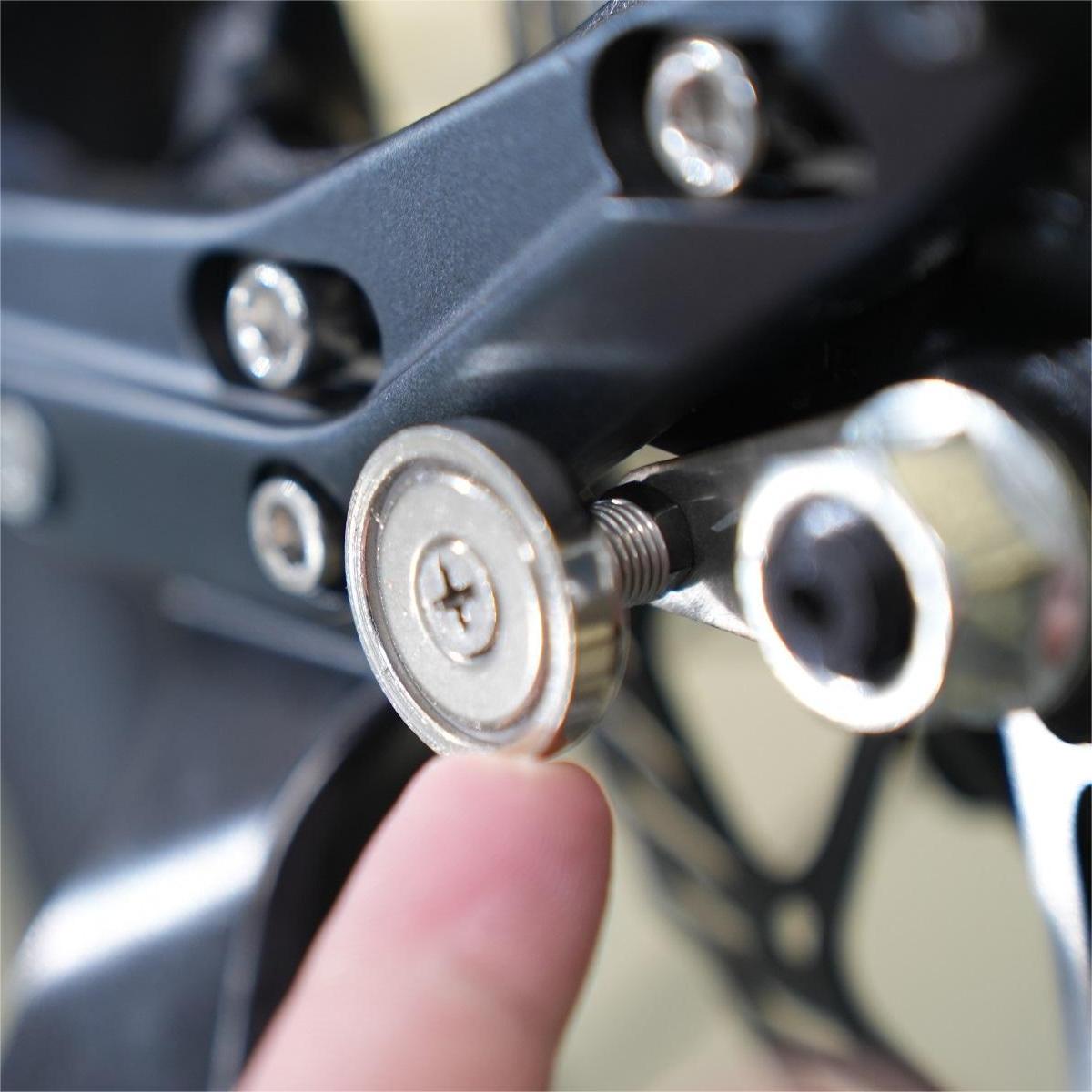 A person is tightening a bolt on a motorcycle using the ADO Air 20 Magnetic Buckle by ADO.