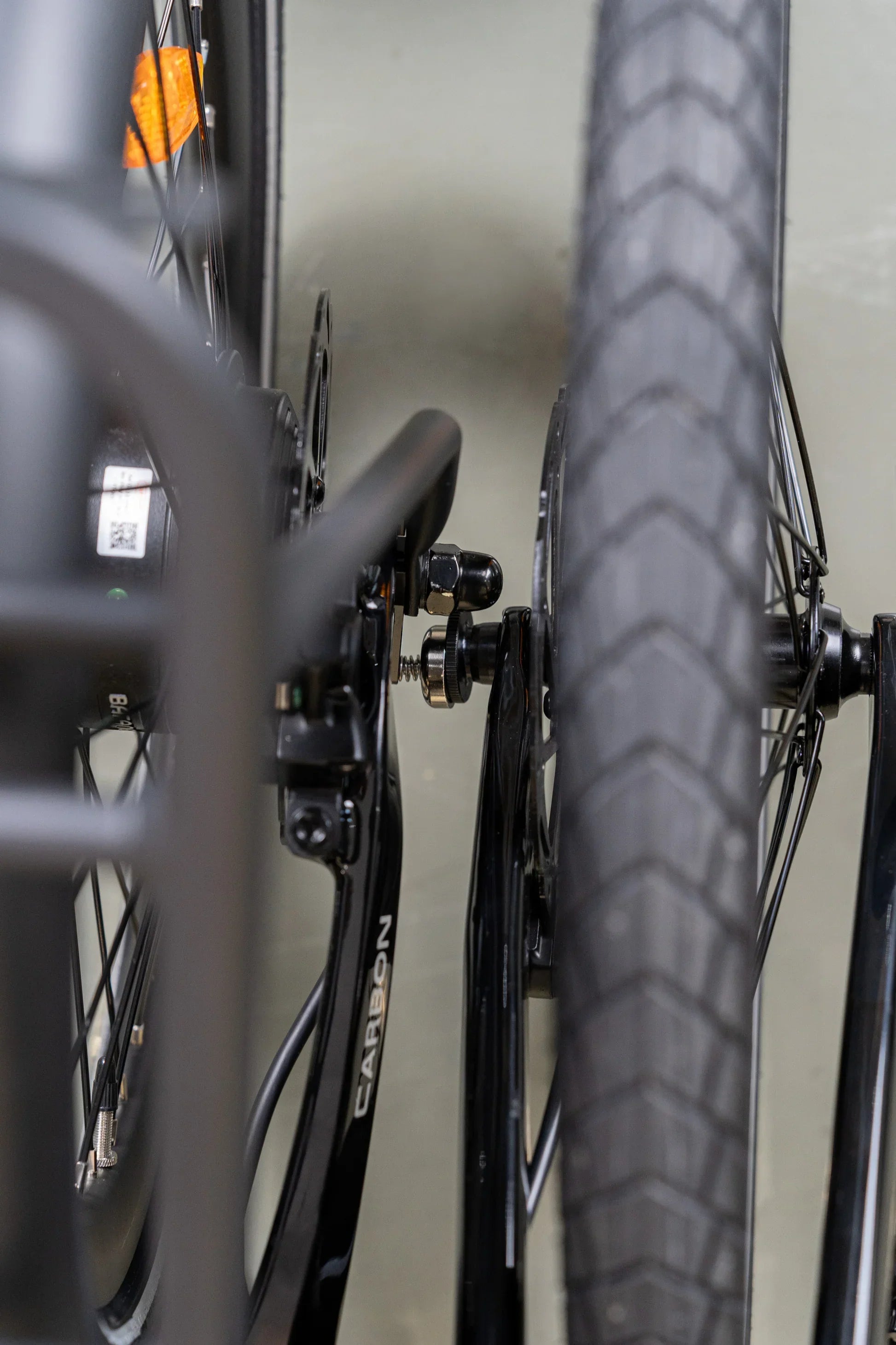 Close-up of a black carbon bike frame and magnetic buckle attachment near the front wheel
