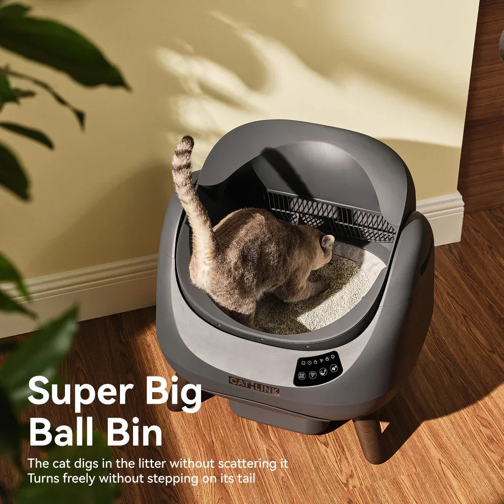 Gray automatic cat litter box labeled Cat Link with a cat digging litter indoors on wooden floor