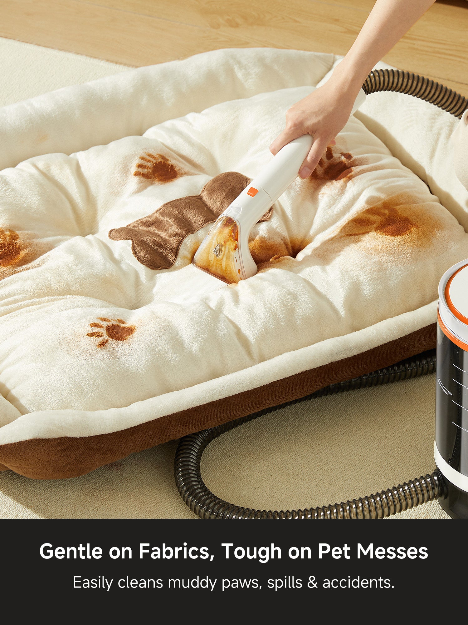 Hand using white carpet cleaner on pet bed with muddy paw stains and brown paw prints