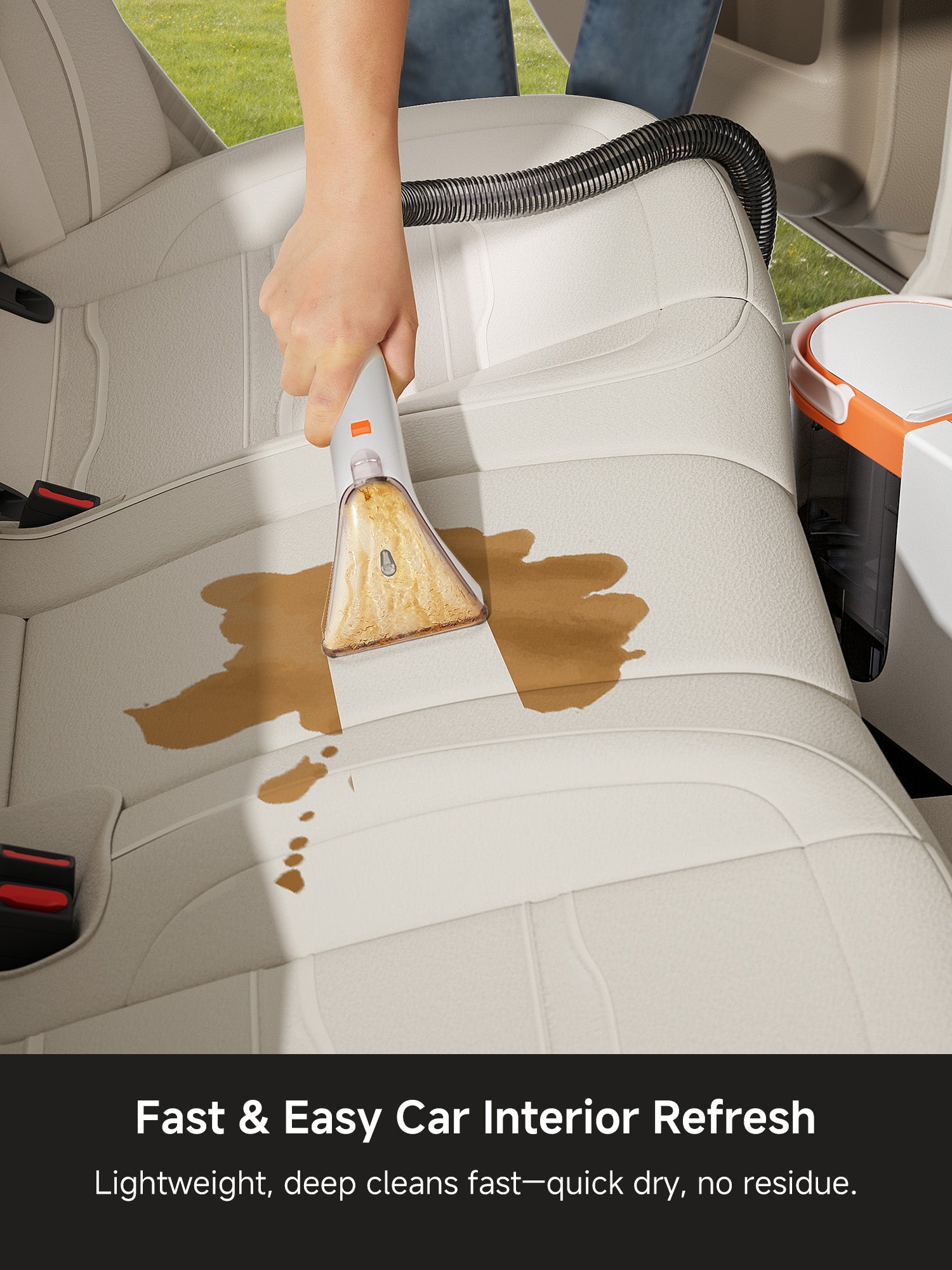 Hand using portable upholstery cleaner on tan car seat removing liquid stain