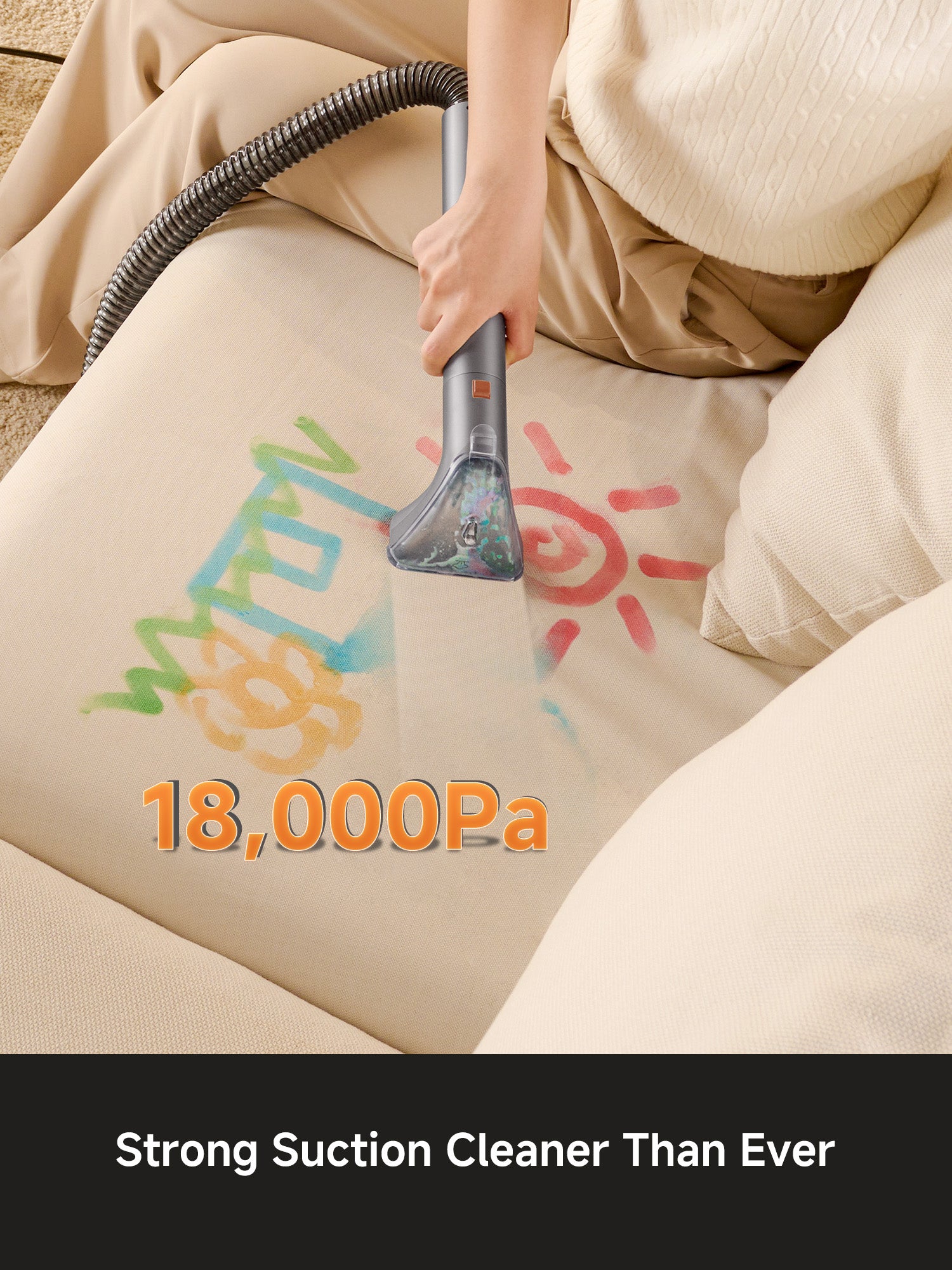Hand using a steam cleaner with strong 18,000Pa suction to remove colorful stains from beige sofa