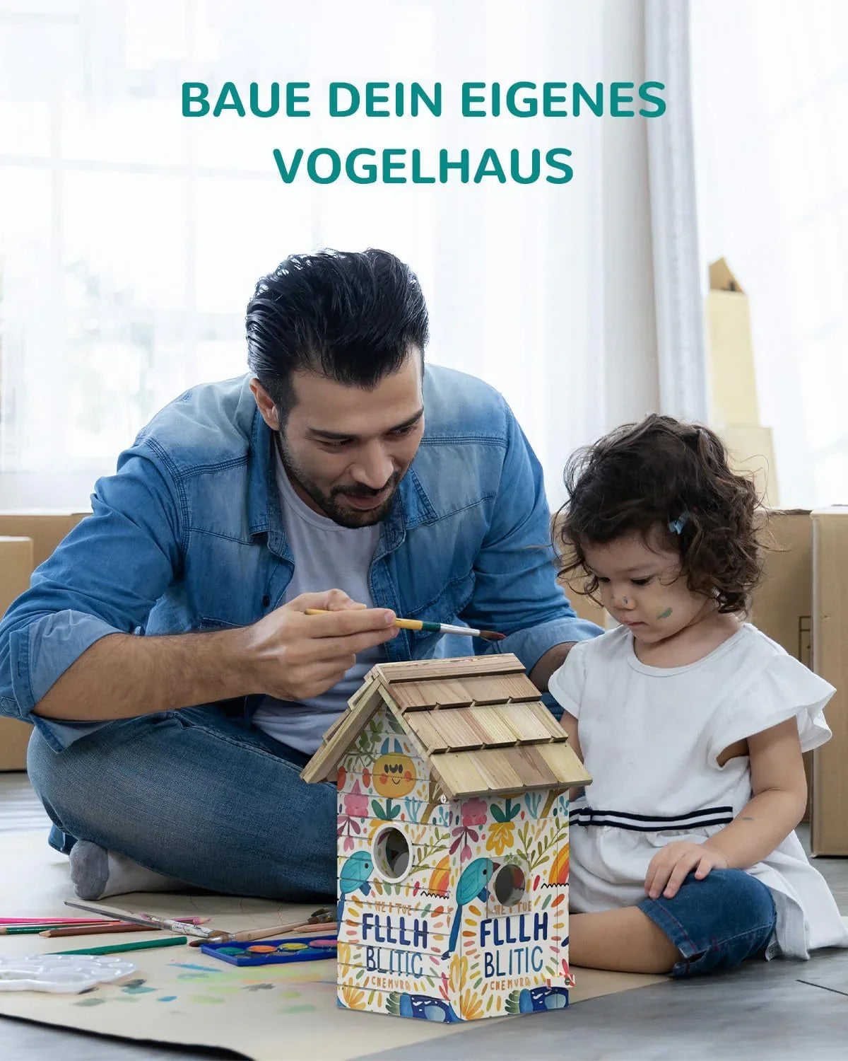 Father and daughter painting a colorful wooden birdhouse indoors with art supplies around