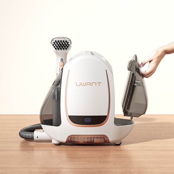 UWANT B100 handheld garment steamer on wooden surface with detachable water tank being removed