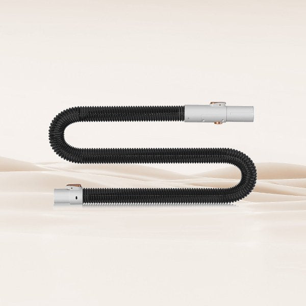 Flexible black vacuum hose assembly with gray connectors on beige background